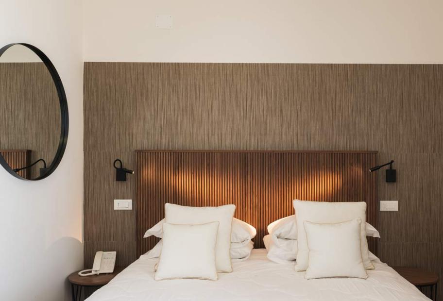 Elegant room with white bed and soft lighting, creating a cozy and relaxing atmosphere.