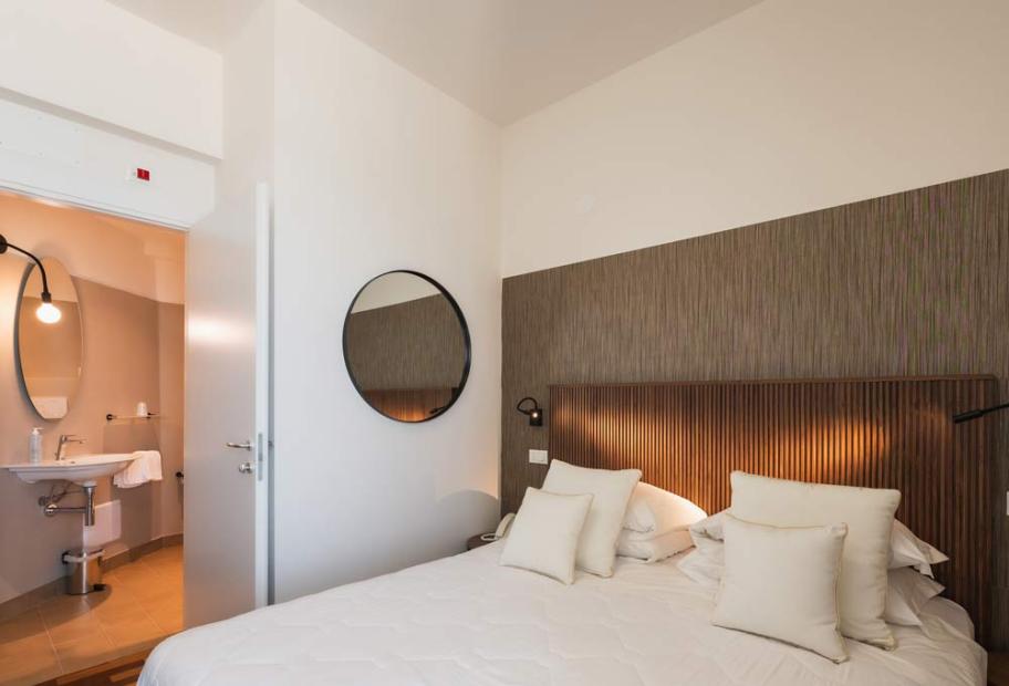 Cozy room with a soft bed, round mirrors, and elegant bathroom.